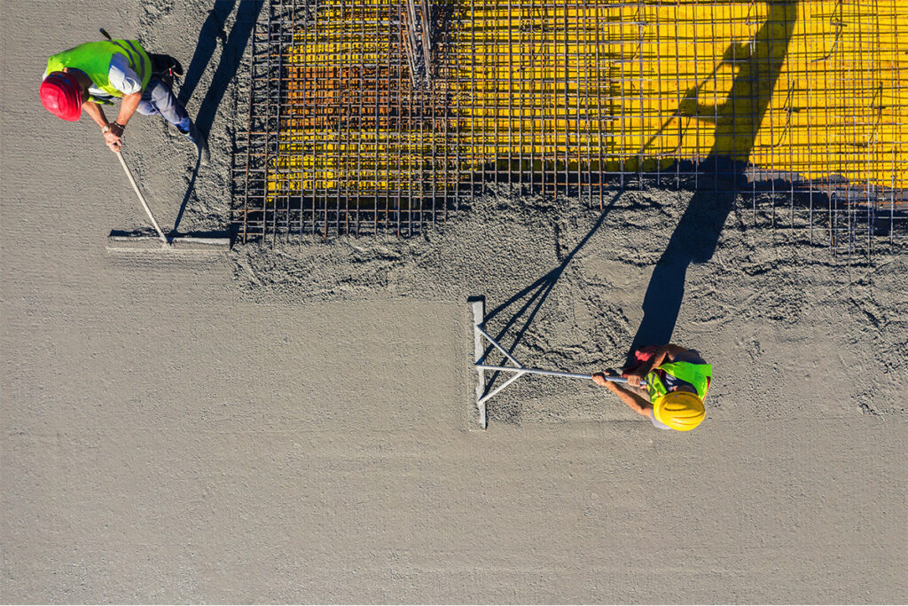 overhead view of men finishing concrete construction on roadway